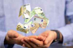 Hand mit schwebenden Geldscheinen