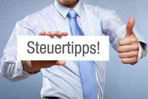 Hand mit Schild mit Aufschrift Steuertipps